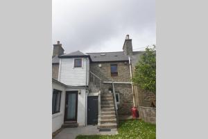 ein Haus mit einer Treppe, die zu einer Garage führt in der Unterkunft Unkenhaus. Cosy, modern apartment, private parking in Lerwick