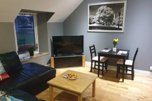 ein Wohnzimmer mit einem Sofa und einem Tisch in der Unterkunft Unkenhaus. Cosy, modern apartment, private parking in Lerwick