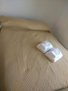 Una cama con dos toallas encima. en Torre Montiel en Tandil