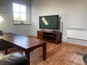 ein Wohnzimmer mit einem TV und einem Couchtisch in der Unterkunft Ferienwohnung Durchholz in Steinhude