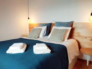 a bed with two towels on top of it at Janela do Porto in Prainha de Baixo