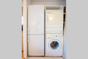 a refrigerator with a washing machine and a washer at Forest flat / Terrasse-spa-bbq-10min à pieds de la plage in La Teste-de-Buch