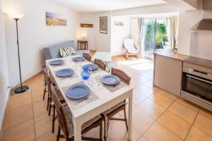 una cocina y comedor con una mesa con placas azules. en Forest flat / Terrasse-spa-bbq-10min à pieds de la plage, en La Teste-de-Buch