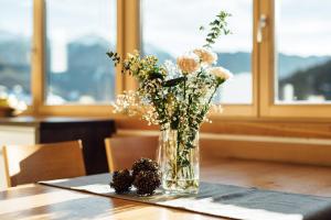un jarrón de flores sentado en una mesa en Schneeweiss lifestyle - Apartments - Living, en Serfaus