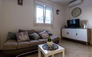 a living room with a couch and a tv at Holiday home Nancy with swimming pool in Vinišće