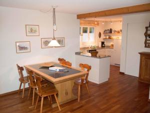 a kitchen and dining room with a wooden table and chairs at Ferienwohnung Bim Stei in Adelboden