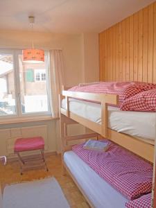 a bedroom with two bunk beds and a window at Ferienwohnung Bim Stei in Adelboden