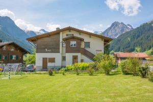 a house with a yard with mountains in the background at Ferienwohnung Bim Stei in Adelboden