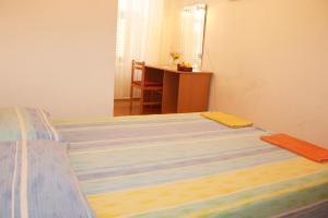 a bedroom with a bed with a desk and a table at Rooms Lazareti in Dubrovnik