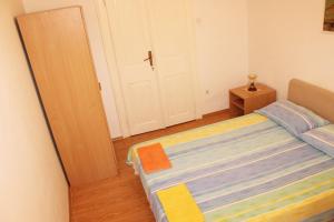 a small bedroom with a bed and a door at Rooms Lazareti in Dubrovnik