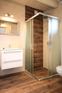 a bathroom with a shower with a glass door at Domki Perłowe in Dąbki