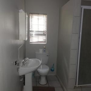 Un baño con inodoro, lavabo y ventana. en Summerwood Contractors Home, en Nelspruit