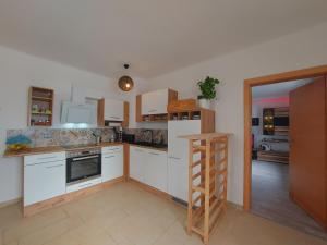 a kitchen with white cabinets and a ladder in it at HAUS SONBERG mit Garten, Pool, Fasssauna, semi detached house with garden in Deutschlandsberg