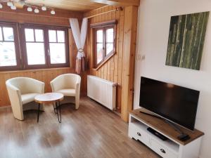 salon z telewizorem, stołem i krzesłami w obiekcie Landhaus Kulm w mieście Bad Mitterndorf
