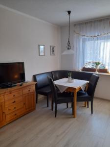 uma sala de estar com uma mesa, um sofá e uma televisão em FW Thormann em Binz