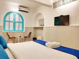 a bedroom with a bed and a tv on the wall at Eros Boutique Hotel in Baga