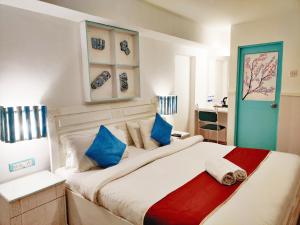 a bedroom with a large bed with blue pillows at Eros Boutique Hotel in Baga