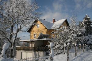 dom pokryty śniegiem z płotem w obiekcie Alte Volksschule - schual in gradne w mieście Liebenfels