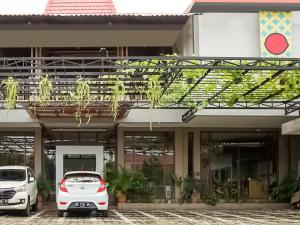 two cars parked in front of a building at Urbanview Hotel Blok O International in Yogyakarta