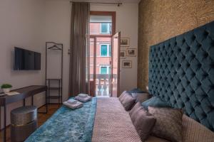 a bedroom with a bed and a desk and a window at B&B Cà del Poeta in Venice
