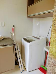 uma lavandaria com uma máquina de lavar roupa e uma escada em Village Imbassaí em Imbassaí