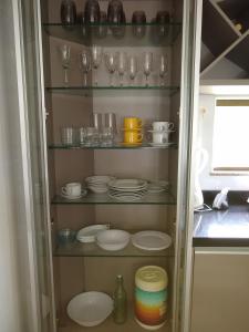 a cupboard filled with plates and glasses and dishes at Village Imbassaí in Imbassai