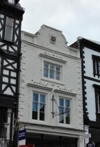 un edificio blanco con un reloj a un lado en Eastgate Hideaway - central, luxury apartment on Chester's historic rows en Chester