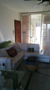 Appartamento policlinico San Donato Milanese في سان جوليانو ميلانيزي: غرفة معيشة مع أريكة بيضاء في غرفة