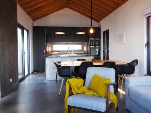 a kitchen and dining room with a table and chairs at Janela do Porto in Prainha de Baixo