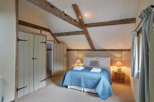 a bedroom with a blue bed with two towels on it at Banningham Coach House in Ingworth