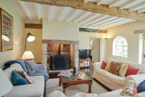 a living room with two couches and a fireplace at Banningham Coach House in Ingworth