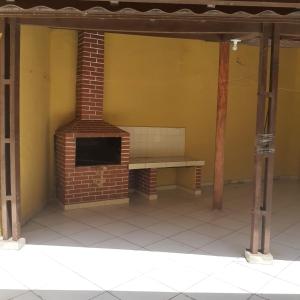 a brick fireplace with a bench in a room at Casa do Sol in Praia Grande