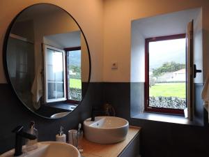 a bathroom with two sinks and a large mirror at Janela do Porto in Prainha de Baixo