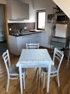 a kitchen with a white table and chairs in a room at attraktives 2-Zimmer-Apartment mit Ausblick in Jena