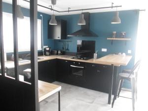 cocina con armarios negros y mesa de madera en L'Atelier en Frehel