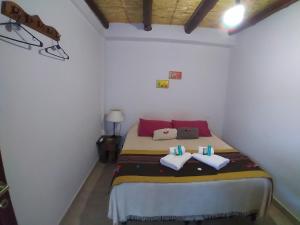 een slaapkamer met een bed met 2 kussens erop bij Los Agustinos in Purmamarca