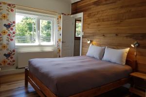 ein Schlafzimmer mit einem Bett mit einer Holzwand in der Unterkunft Hostal Compass del Sur in Puerto Varas