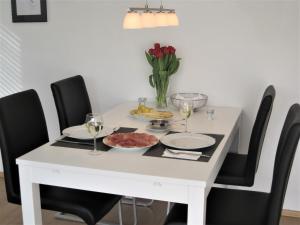 a white dining room table with black chairs and wine glasses at Appartement Panoramablick in Baden-Baden