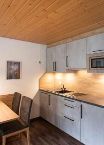 a kitchen with a sink and a table with chairs at Apartment Madlaina in Samnaun