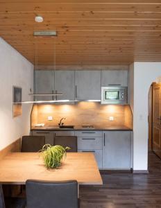 a kitchen with a wooden table and a microwave at Apartment Madlaina in Samnaun