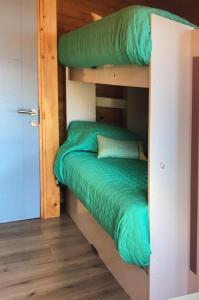 Litera en habitación con edredón verde en Condominio Privado a Pasos del Mar, en Pichilemu