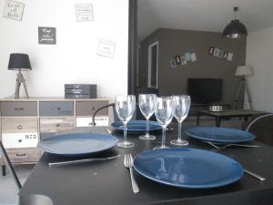 una mesa con platos azules y copas de vino. en L'Atelier en Frehel
