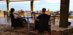 un hombre y una mujer sentados en una mesa en un restaurante en Castella Beach en Alissos