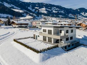 una casa en la nieve con montañas en el fondo en Apart Schachinger en Uderns