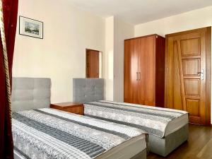 2 łóżka w pokoju z drewnianymi drzwiami w obiekcie Agroturystyka Pod Jodłami w mieście Kołaki Wietrzychowo