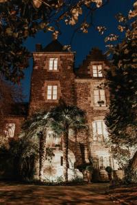 un vieux château avec des palmiers devant lui dans l'établissement Castel Jolly, à Rennes