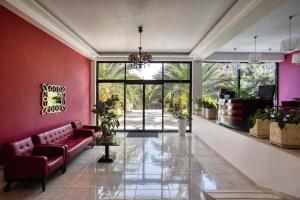 een lobby met roze muren en een rode bank bij Hotel Apsara in Pitsoenda