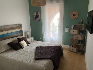 una camera da letto con un grande letto con pareti verdi di Charmant T2 refait à neuf a Calvi