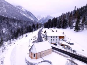 a small building in the snow next to a mountain at Rifugio Ospitale in Cortina dʼAmpezzo