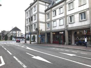 an empty street in front of a large building at Chez F&J in Elbeuf